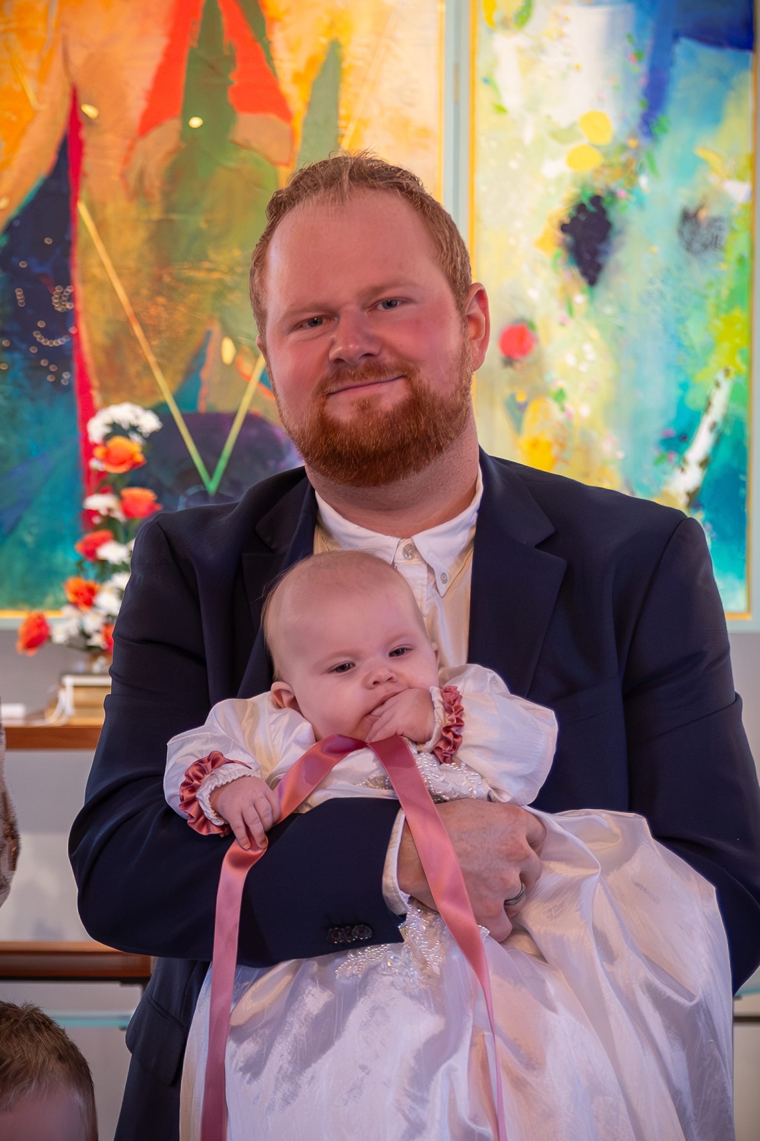 Far holder sin baby i dåbskjole